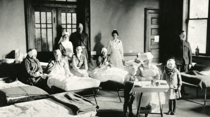 YMCA Emergency Hospital, nurses and patients pose for a photograph in their beds.