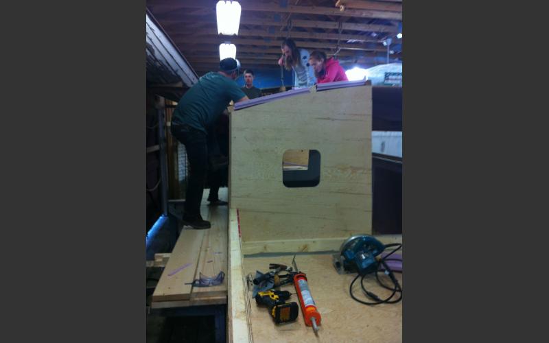 The Art Boat gets walls and windows! Brian cuts a square portal to let light into the cabin/gallery while Kate and Nina enjoy the view!