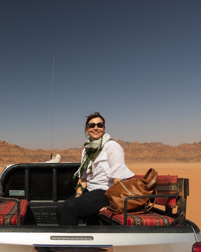 Louise Trotter sitting in the back of a truck in the desert. 