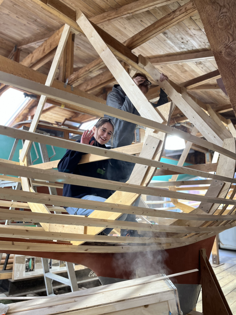 A student building the frame of a boat in the boat shed at the Maritime Museum of the Atlantic.