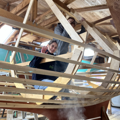 A student building the frame of a boat in the boat shed at the Maritime Museum of the Atlantic.