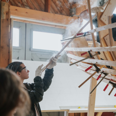 Students steam bending a wood boat from in the boat shed at the Maritime Museum of the Atlantic.