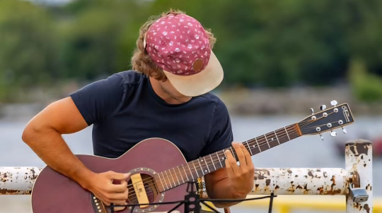 Skyler Stetler playing guitar outside.